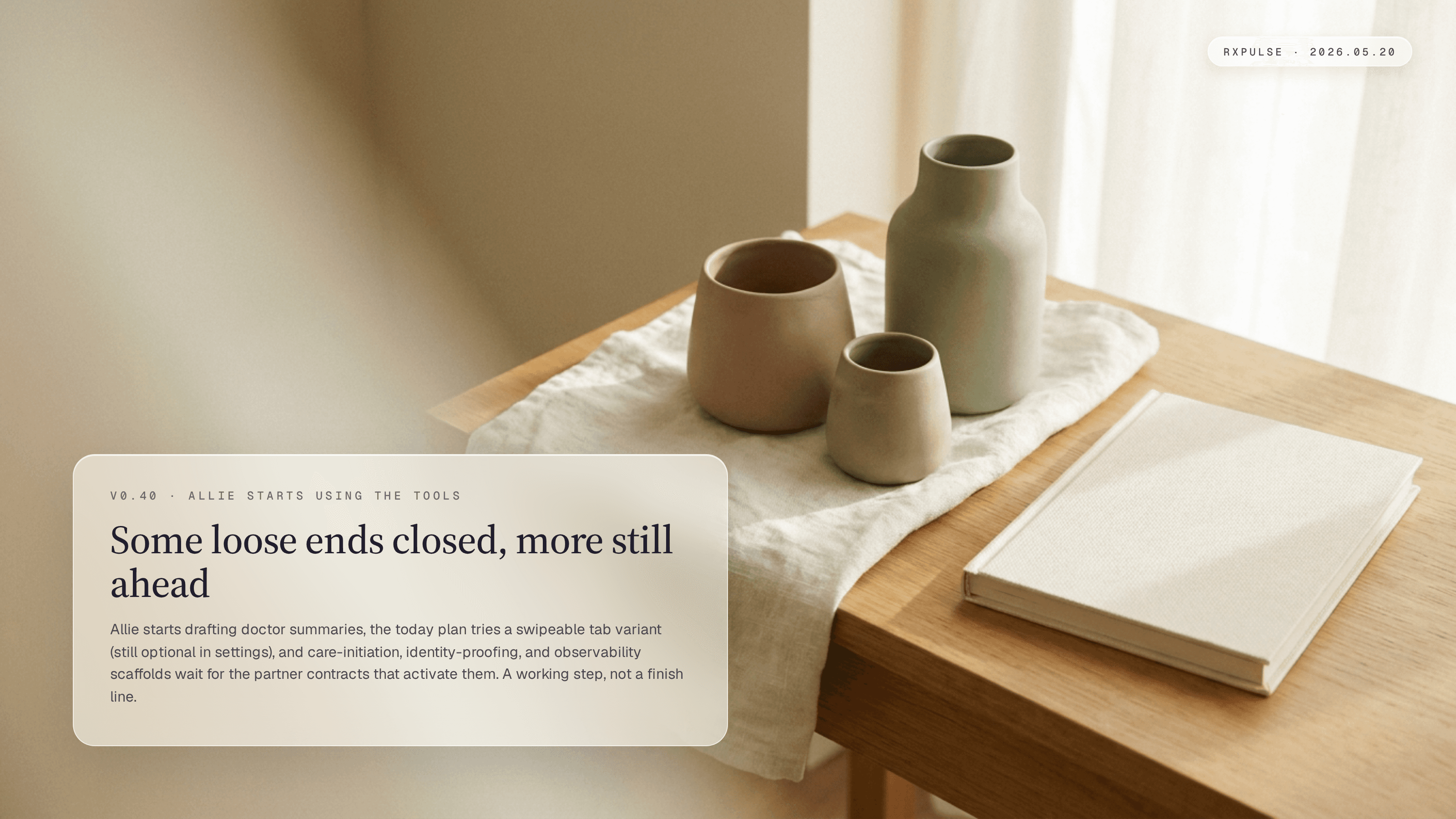 Editorial release artwork. Two or three hand-poured ceramic vessels arranged on folded linen with a closed notebook resting beside them; afternoon light catches a clean wooden surface. The caption card reads v0.40 with a short note about the table being set before the cohort arrives.