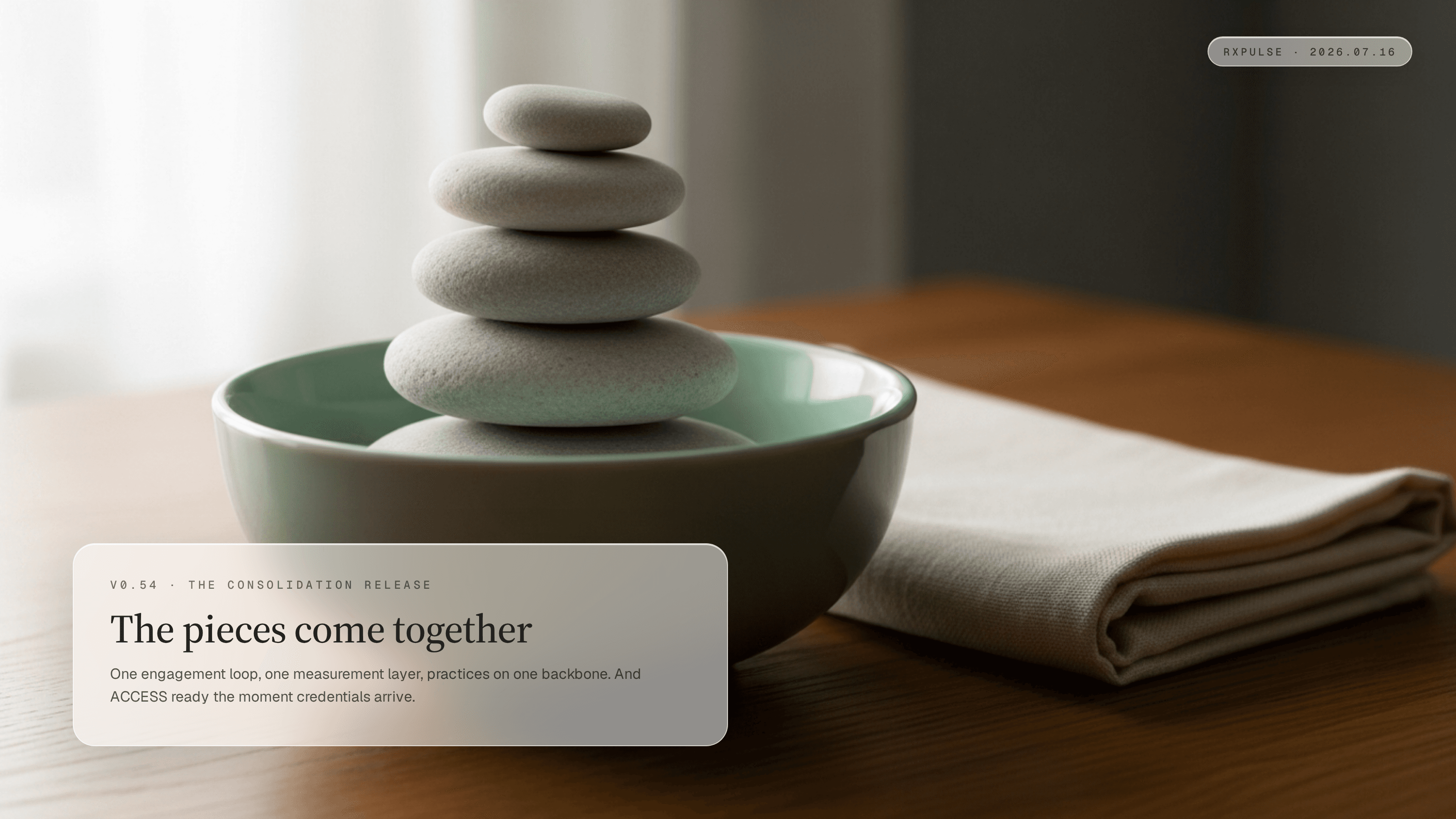 Smooth pale stones stacked in a mint ceramic bowl beside folded cream linen on a warm oak table in soft morning light.