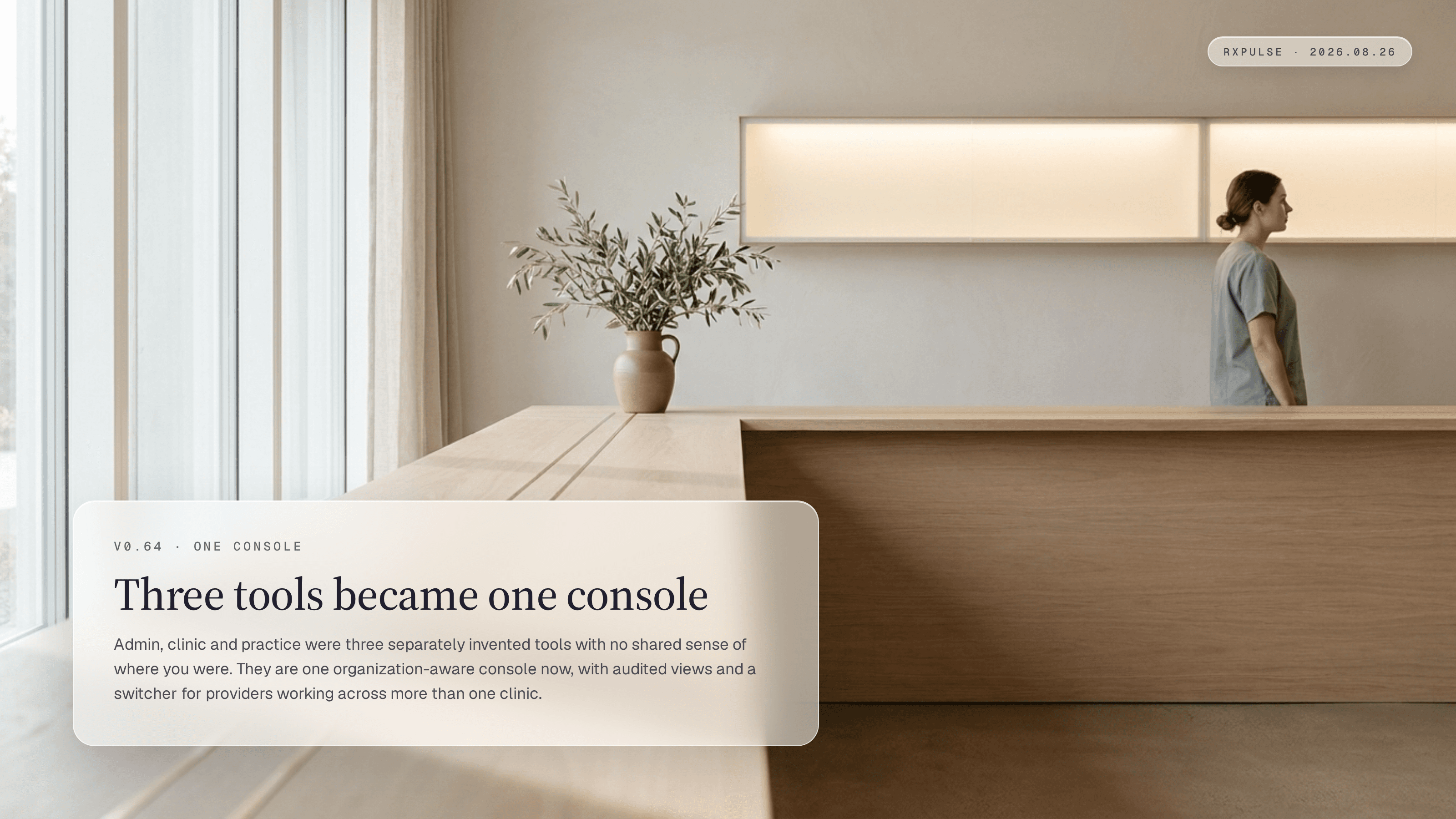 Release hero art: one long unbroken pale oak counter running the length of a sunlit clinical operations room, with two fine brass inlay lines marking where three separate desks used to meet, a clinician standing at the far end, and a single continuous lit glass panel above. Captioned "Three tools became one console."