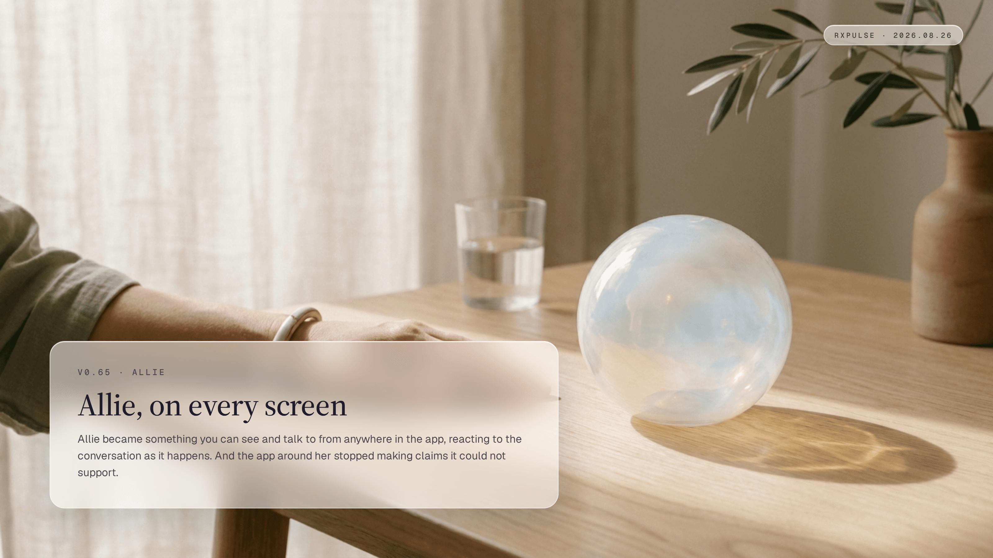 Release hero art: a softly glowing sphere, like a small weather cloud held inside hand-blown glass, resting on a pale oak table in morning light with a hand at rest beside it. Captioned "Allie, on every screen."
